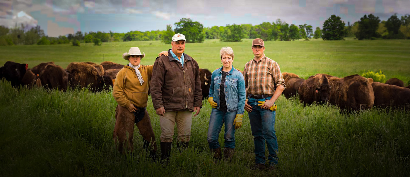 Group of four on farm with bison in background