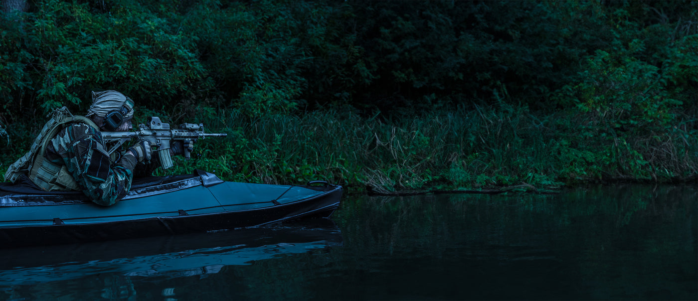 A Soldier in small boat with guns out